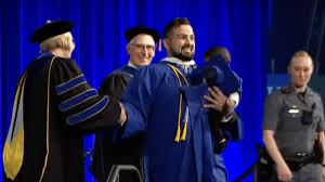University at Buffalo Graduate Runs Across Stage with Infant Son Despite Police Attempts to Stop Him During Graduation Ceremony