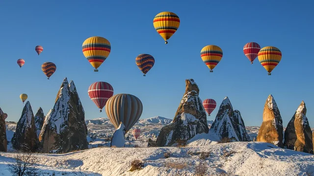 Tourists wake up to a fairytale view as hot air balloons rise over the fairy chimneys and stone-carved churches of Göreme in Cappadocia