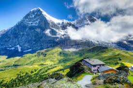 Hikers embrace breathtaking alpine views as the Eiger Trail winds beneath the legendary North Face in the Bernese Alps
