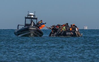 French Police boat hands lifejackets to migrants crossing the English Channel