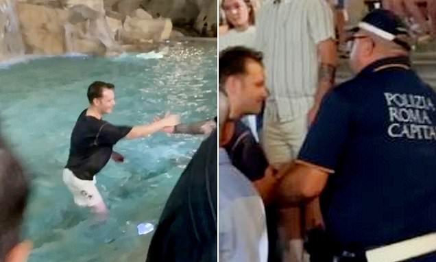 Smirking tourist shocks the crowd in Rome as he leaps into the 263 year old Trevi Fountain before police remove him from the landmark