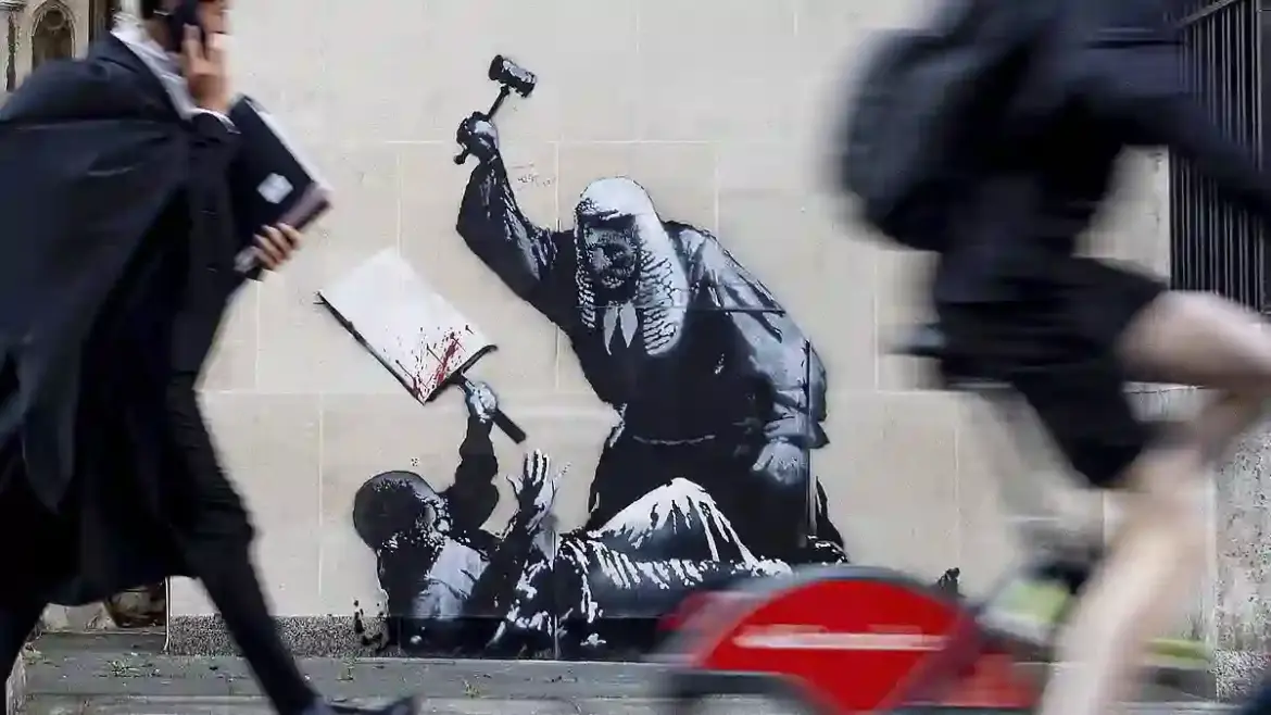 Banksy sparks police investigation after spraying mural of judge hitting protester on Royal Courts of Justice in London