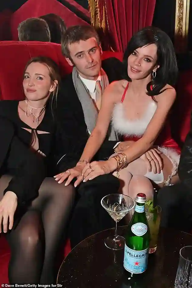 Lily Allen turns heads at her London Christmas party by sharing a passionate kiss with Jonah Freud and wearing a sultry red velvet revenge dress