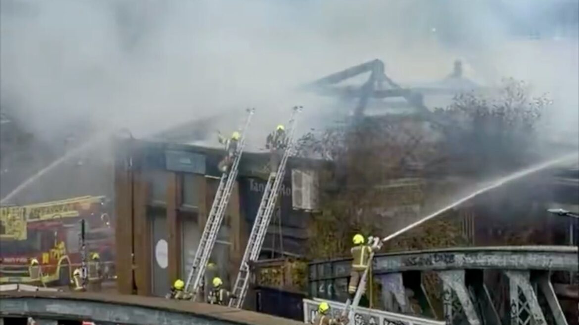 Blaze engulfs commercial building near Chalk Farm while 70 firefighters work tirelessly to control flames and delay rail services