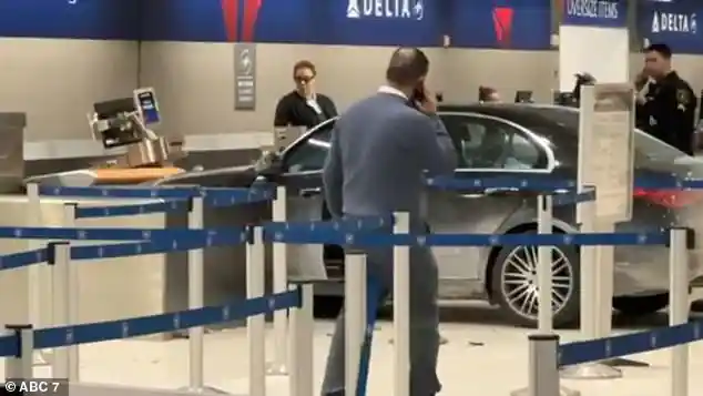 Man smashes car through Detroit Metro Airport check-in area before being dragged away by police inside the McNamara Terminal