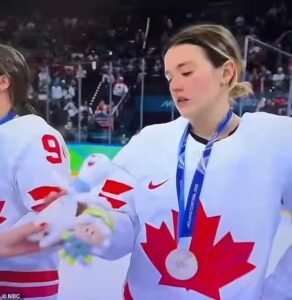 Team Canada women’s hockey players receive small mascot after losing intense overtime match to Team USA in Milan during 2026 Winter Olympics