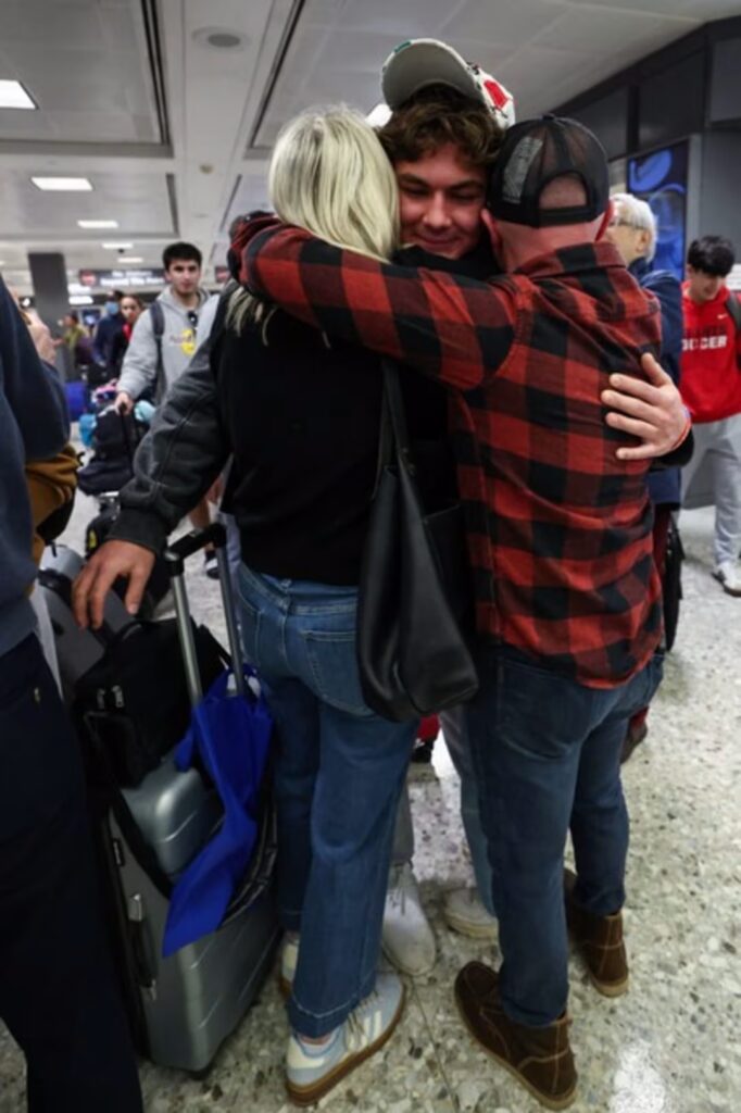 Aidan Korn hugs his parents, Karen and Jason Korn, at Dulles Airport in Virginia upon his safe return