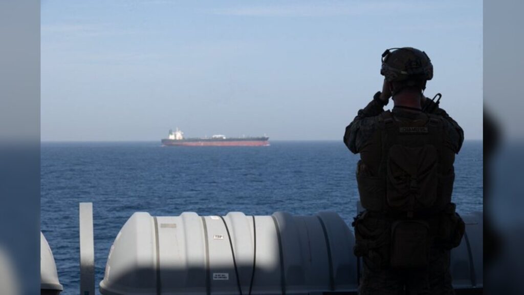 A U.S. Marine aboard the forward-deployed amphibious transport dock ship USS New Orleans (LPD 18) monitors shipping during U.S. maritime blockade operations