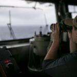 A U.S. Sailor stands watch on the bridge of USS Tripoli (LHA 7) while transiting the Arabian Sea